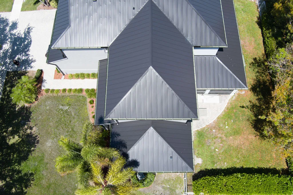 Aerial view of a modern home with a black metal roof and symmetrical design on the Treasure Coast