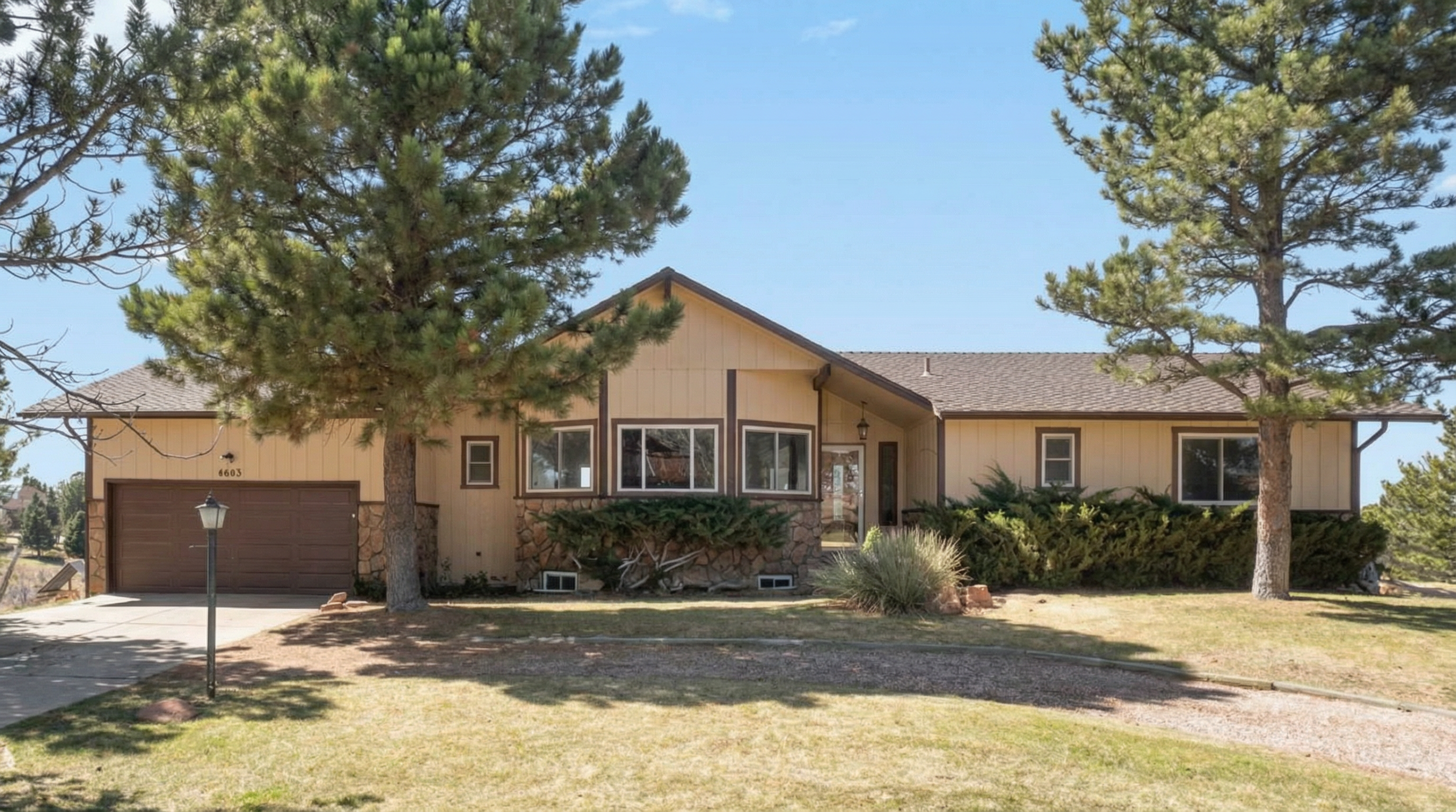 Charming single-story home with beige exterior and stone accents
