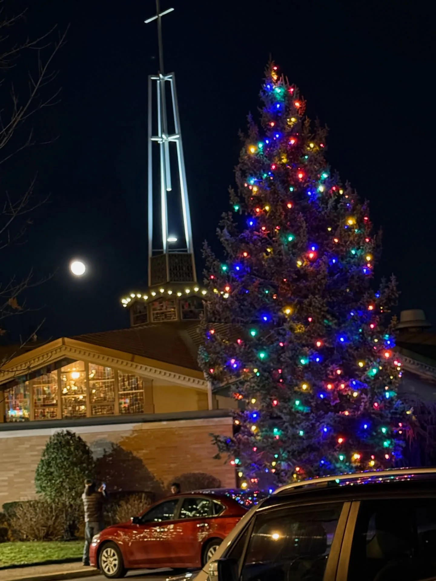 Brightly lit church with festive lights and tall steeple