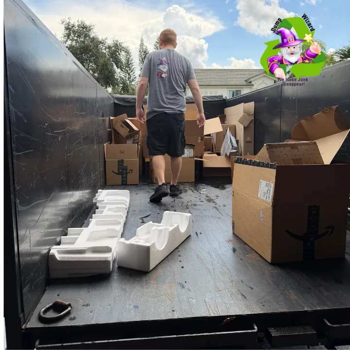 Chase stacking boxes inside the Dump Wizard trailer during a cleanout