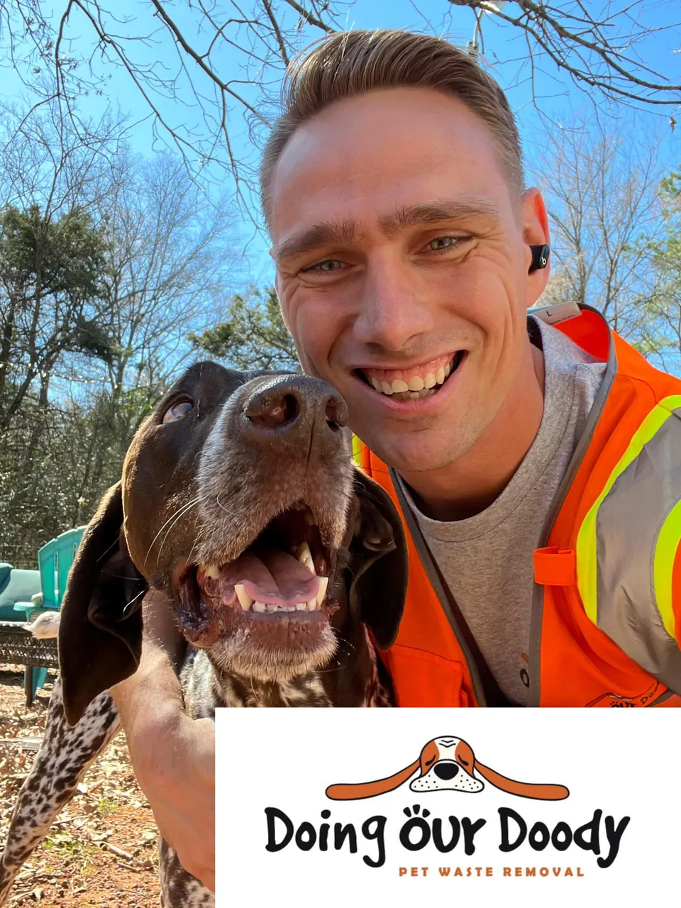 Smiling Doing Our Doody technician with a happy dog after finishing a weekly cleanup