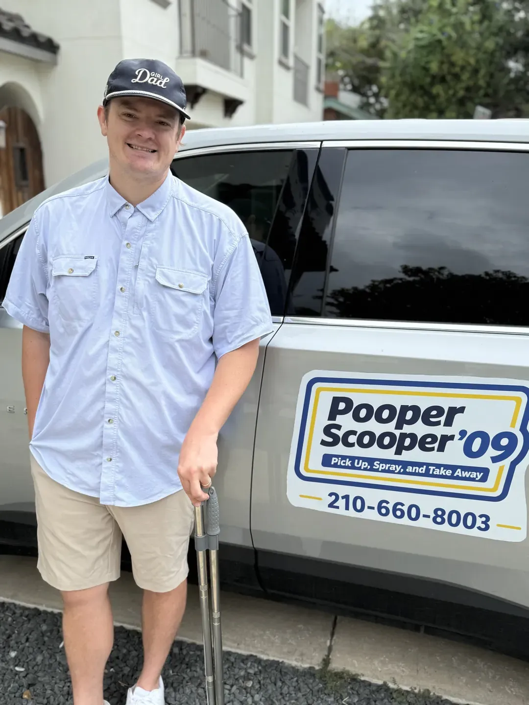 B.P. Foley, owner-operator of Pooper Scooper '09, smiling beside the company SUV with a pet waste rake