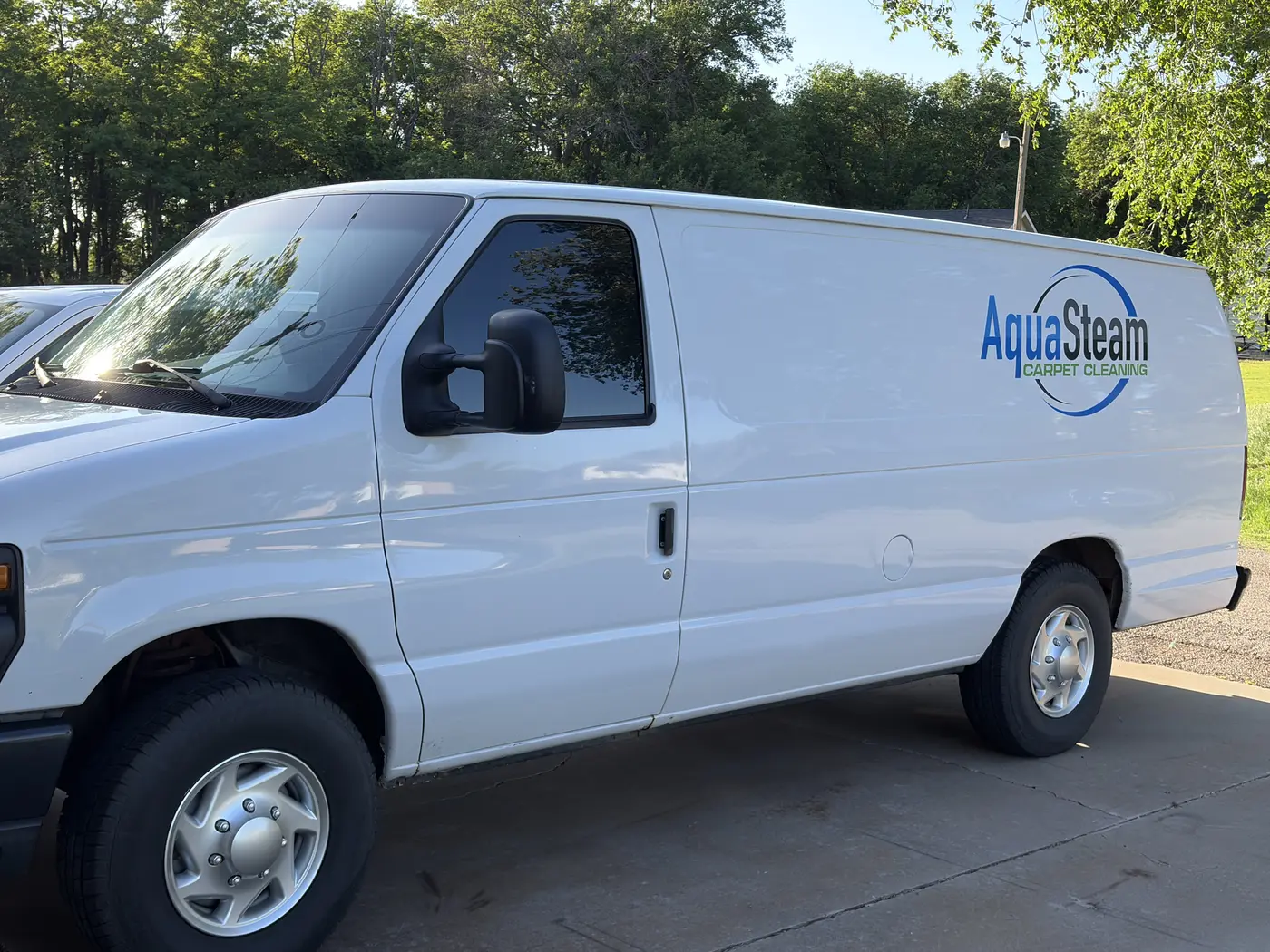 Side of the white Aqua Steam Carpet Cleaning van with its logo
