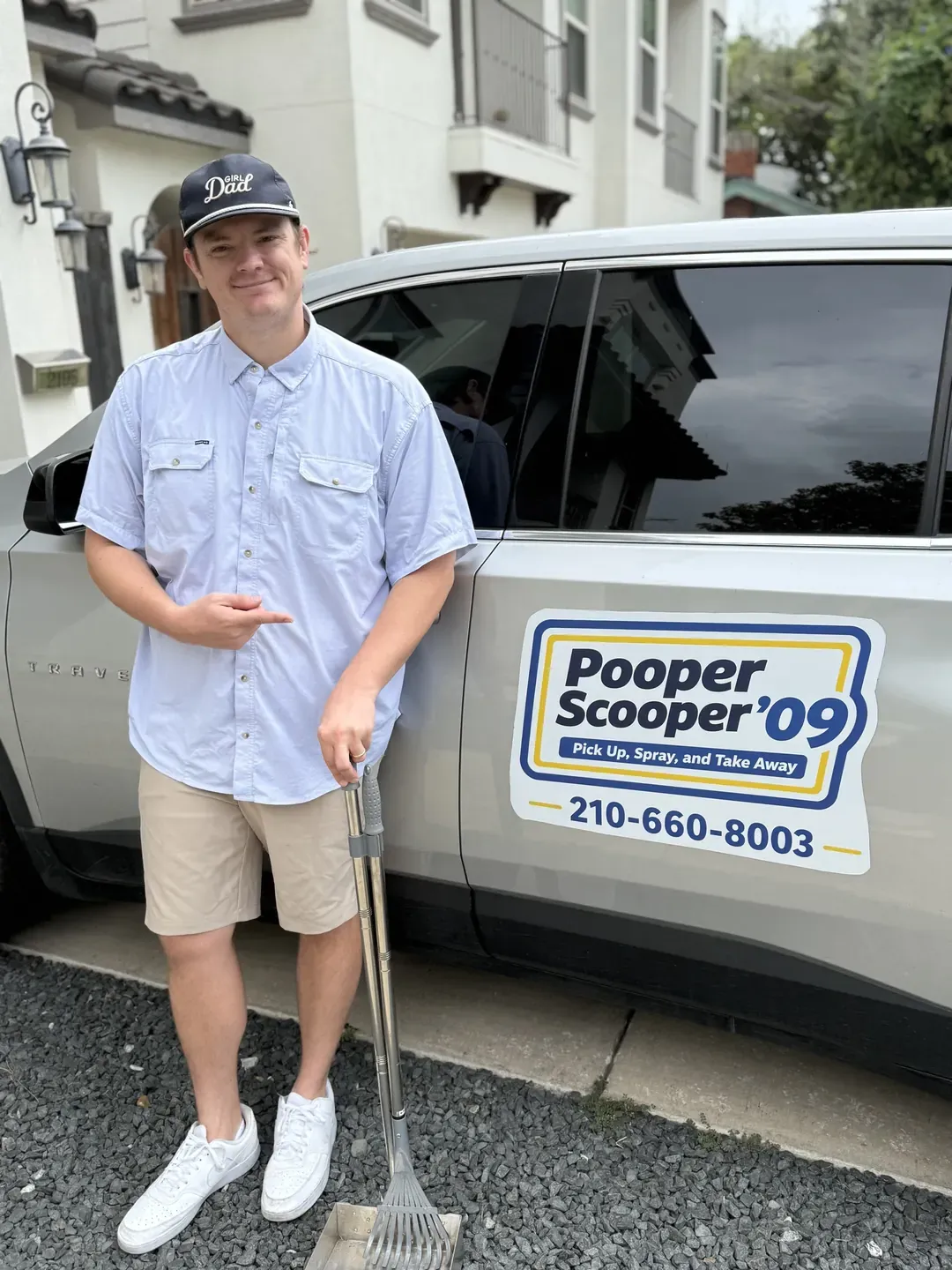 B.P. Foley pointing to the Pooper Scooper '09 logo and phone number on his SUV door