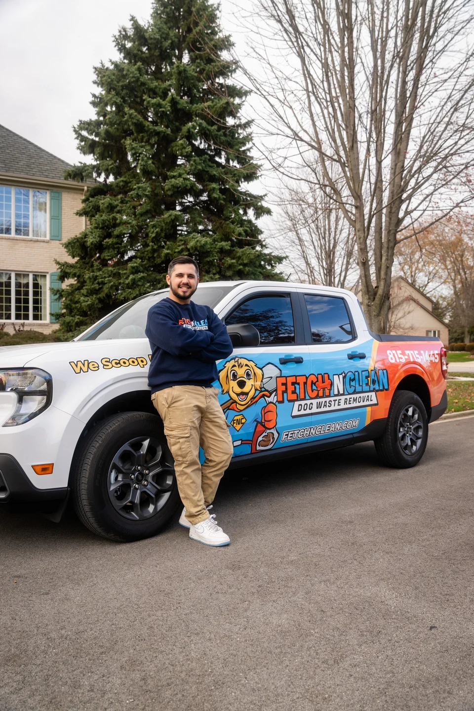 Man standing next to a Fetch N Clean branded vehicle featuring a cartoon dog graphic.