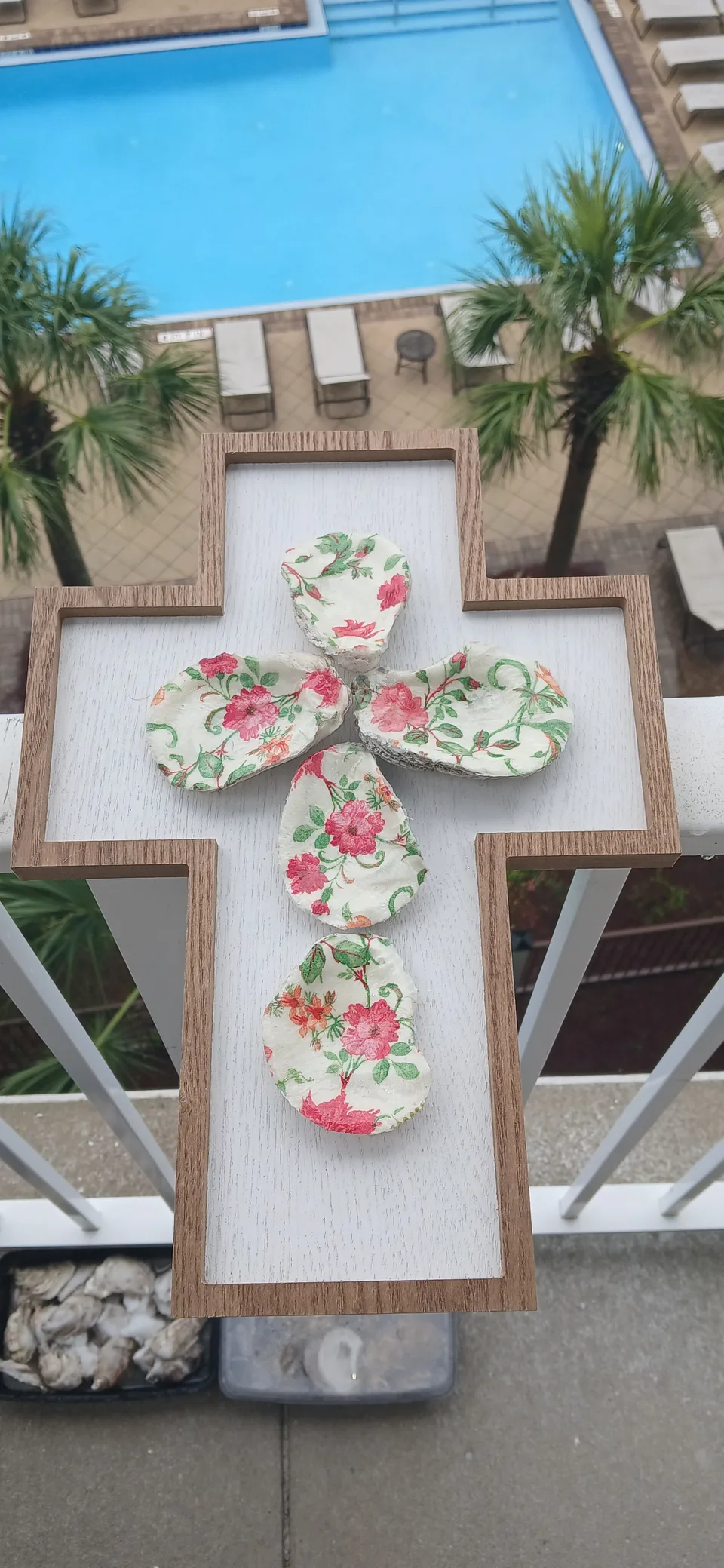 Wood-edged white cross decorated with five shells in pink and green floral patterns
