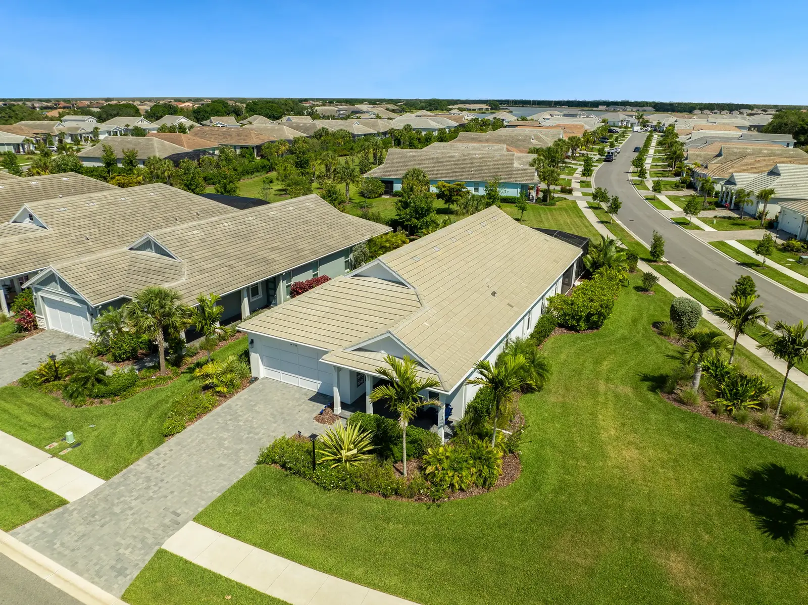 Aerial of a large single-storey custom home with a tile roof and landscaped grounds in a Sarasota community.