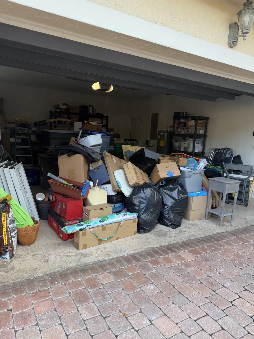 Parkland garage crammed with boxes, bins, and trash bags before the cleanout