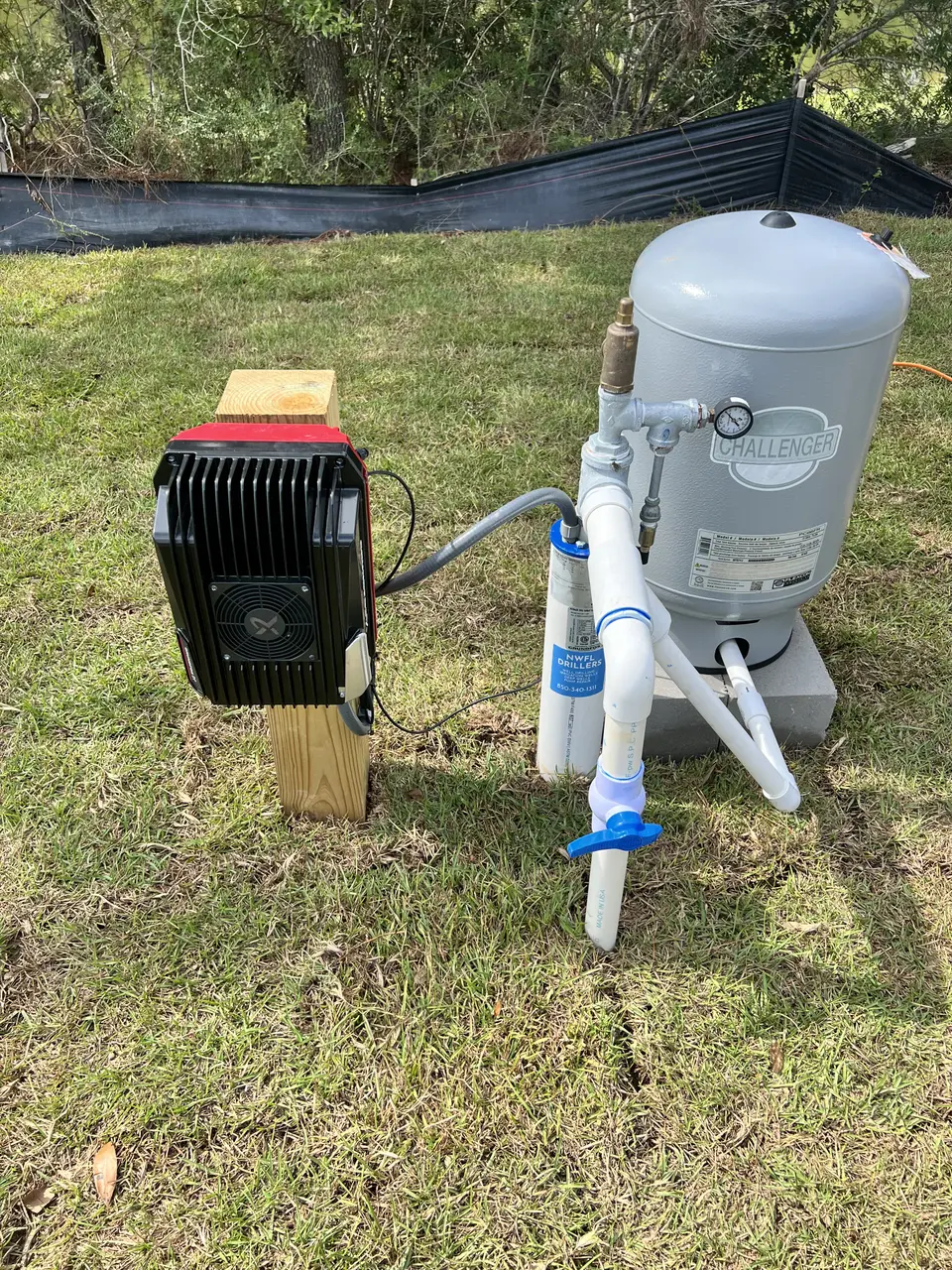 Challenger storage tank and pump mounted on a wooden base with PVC piping