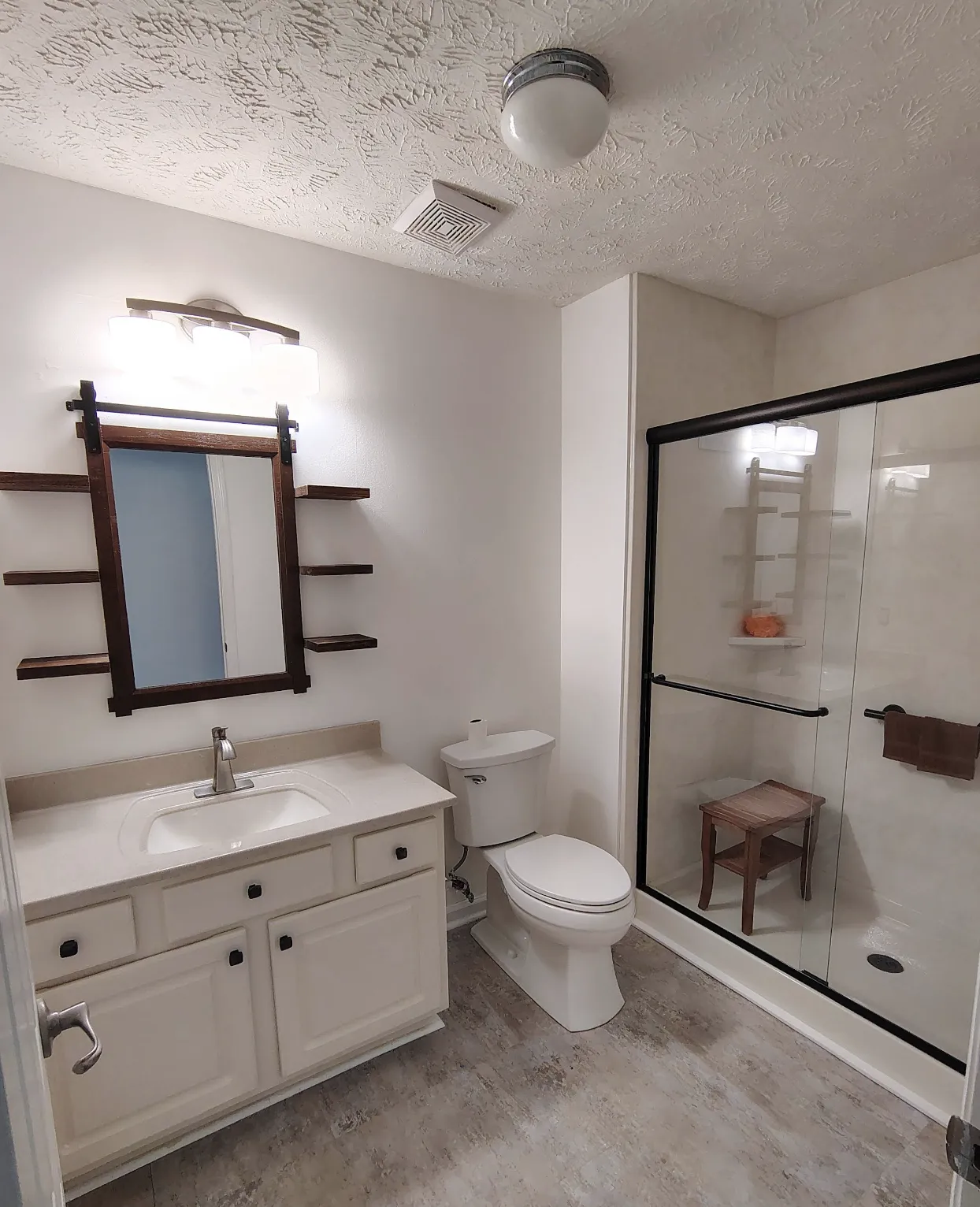 Clean modern bathroom with a white vanity, glass shower enclosure, and fresh fixtures after installation