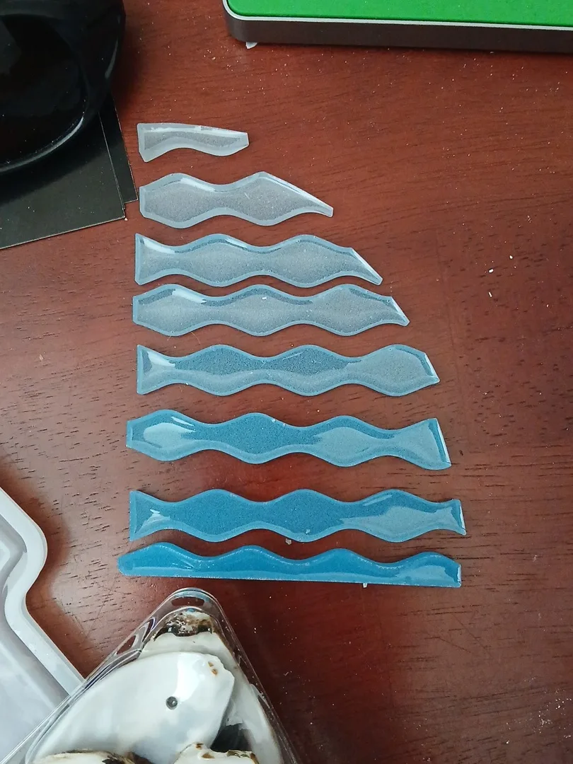 Eight blue and pale wave-shaped pieces arranged on a wooden tabletop