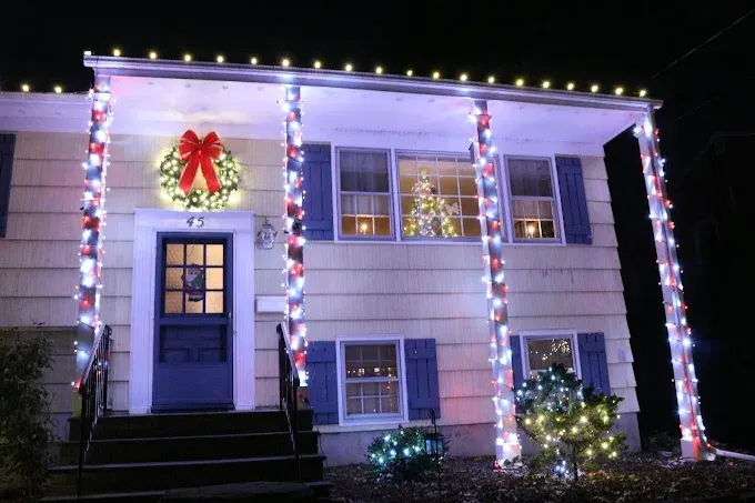 Festively decorated two-story home with blue, white and red holiday lights in Paramus