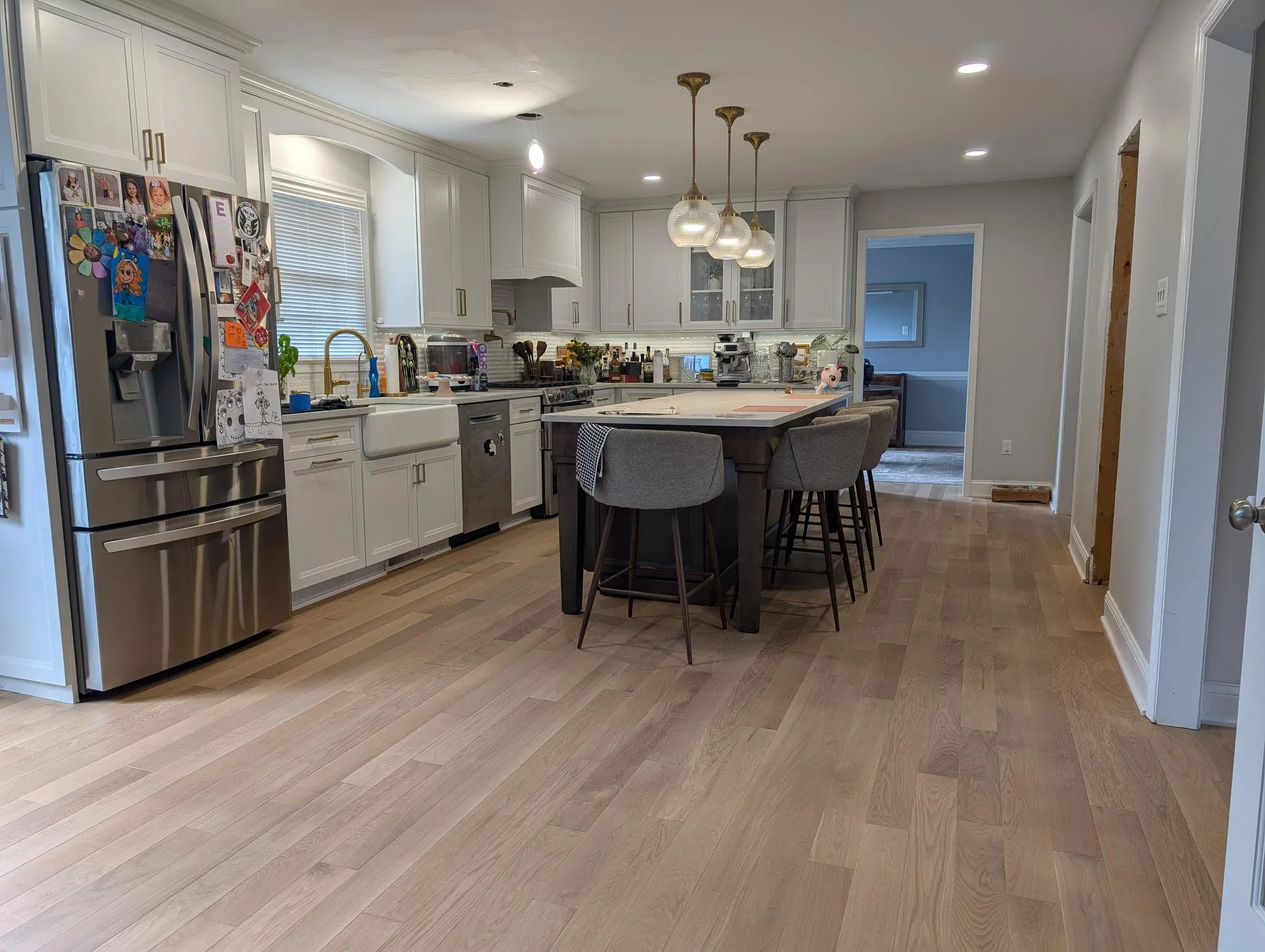 Bright kitchen with hardwood flooring and white cabinetry
