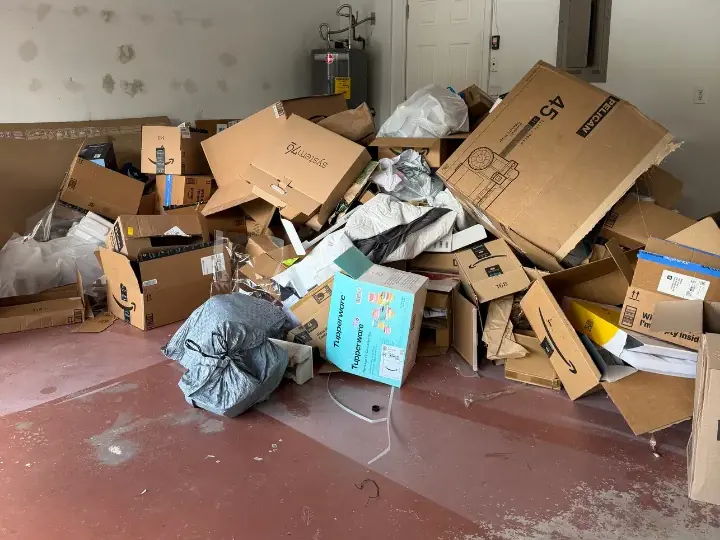 Garage filled with boxes, bags, and packing debris before a Dump Wizard cleanout