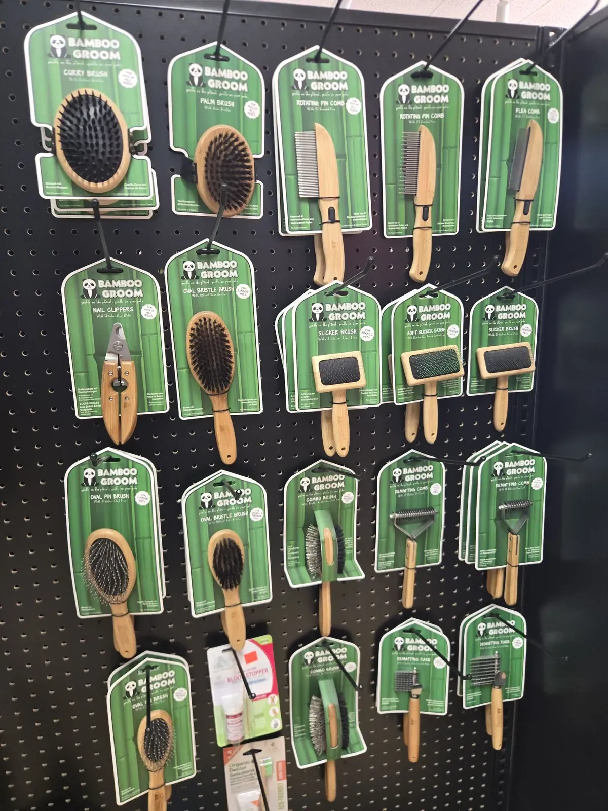 A pegboard wall of Bamboo Groom brushes, combs, nail clippers and dematting tools for sale at Dog O Mat