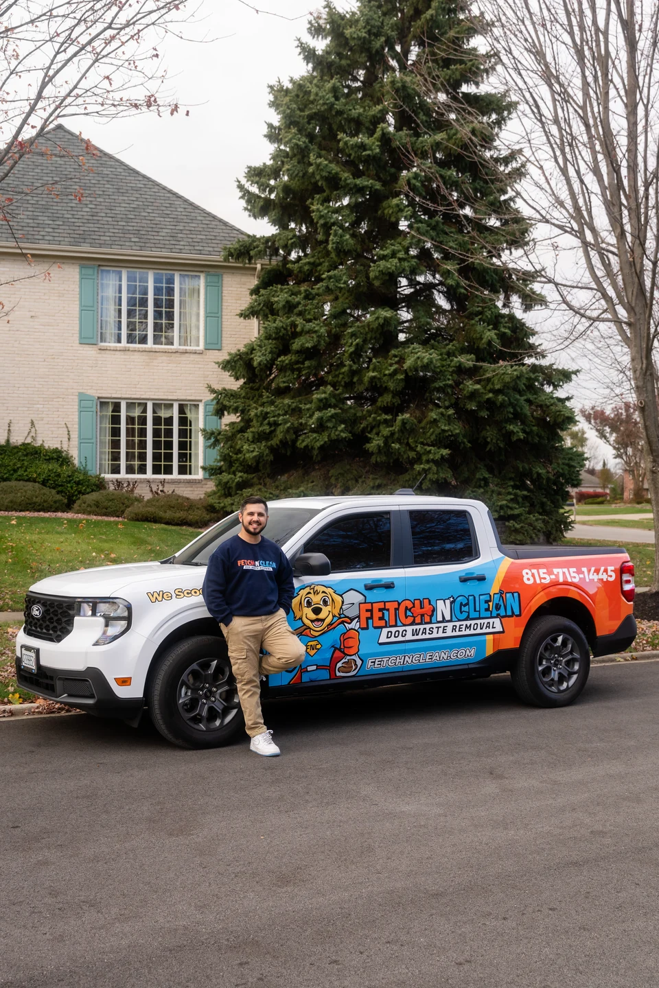 Man beside a colorful Fetch N Clean branded vehicle in front of a house.
