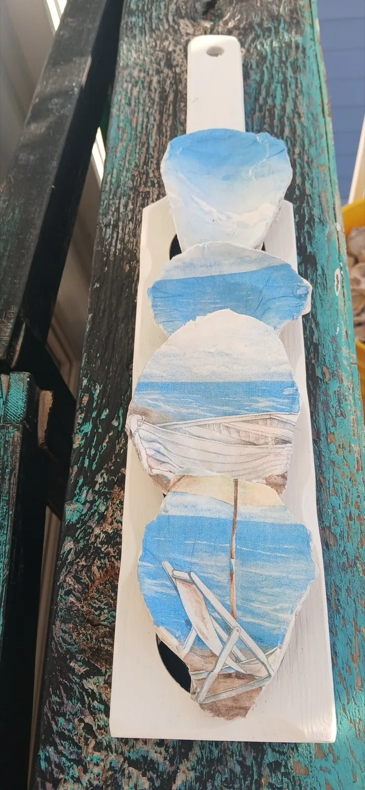 White oyster flight board with blue wave-painted shells and a twine-wrapped handle