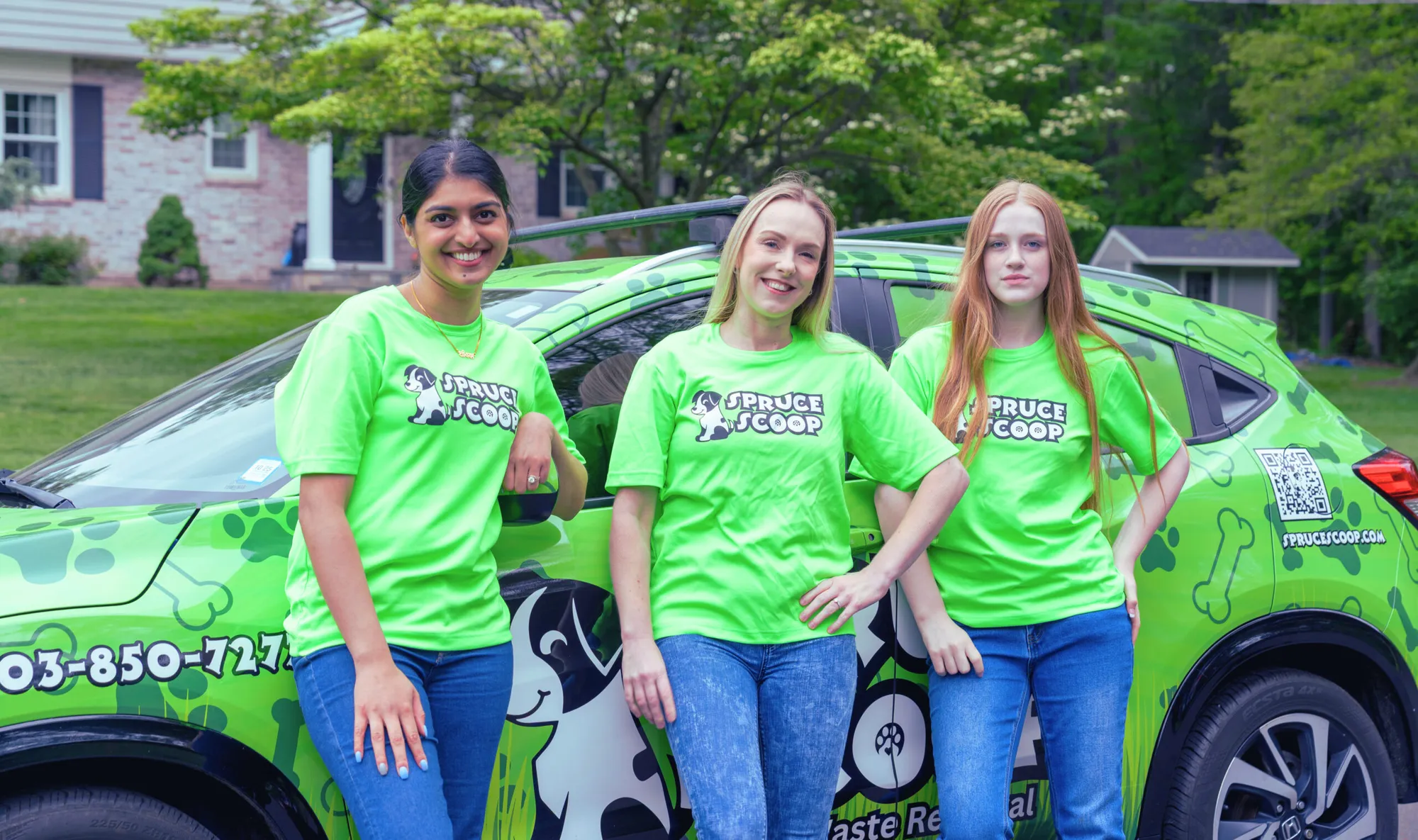 Three smiling Spruce Scoop technicians in green branded shirts leaning on a wrapped Spruce Scoop car outside a home
