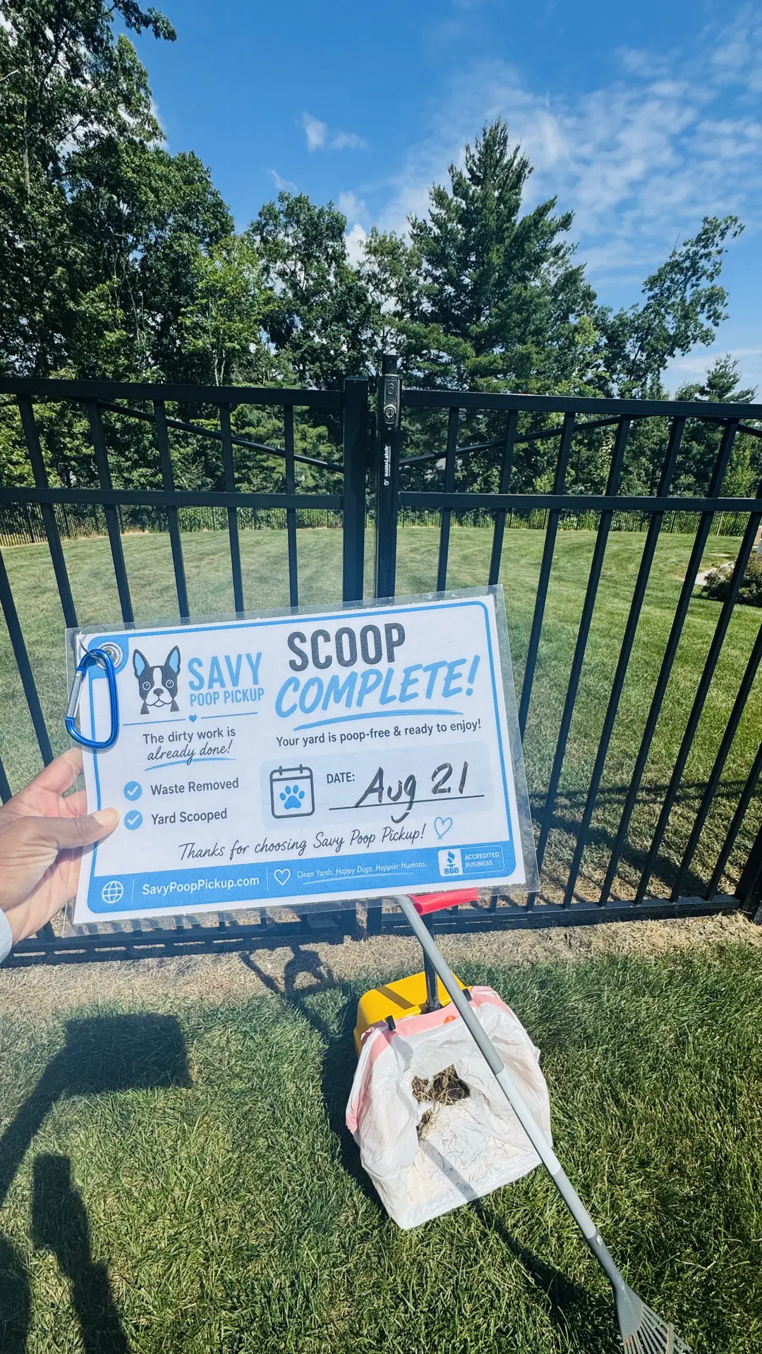 Scoop Complete card left in a customer yard next to a waste collection bag and rake