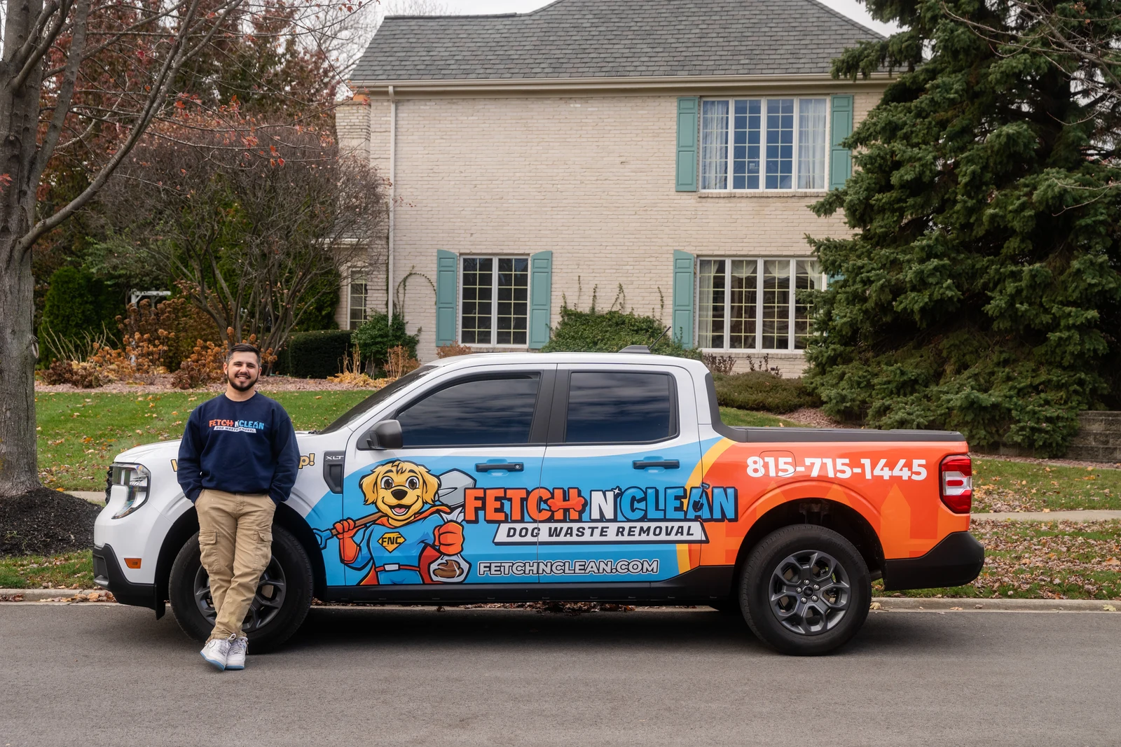 Fetch N Clean branded pickup truck parked in front of a residential home.