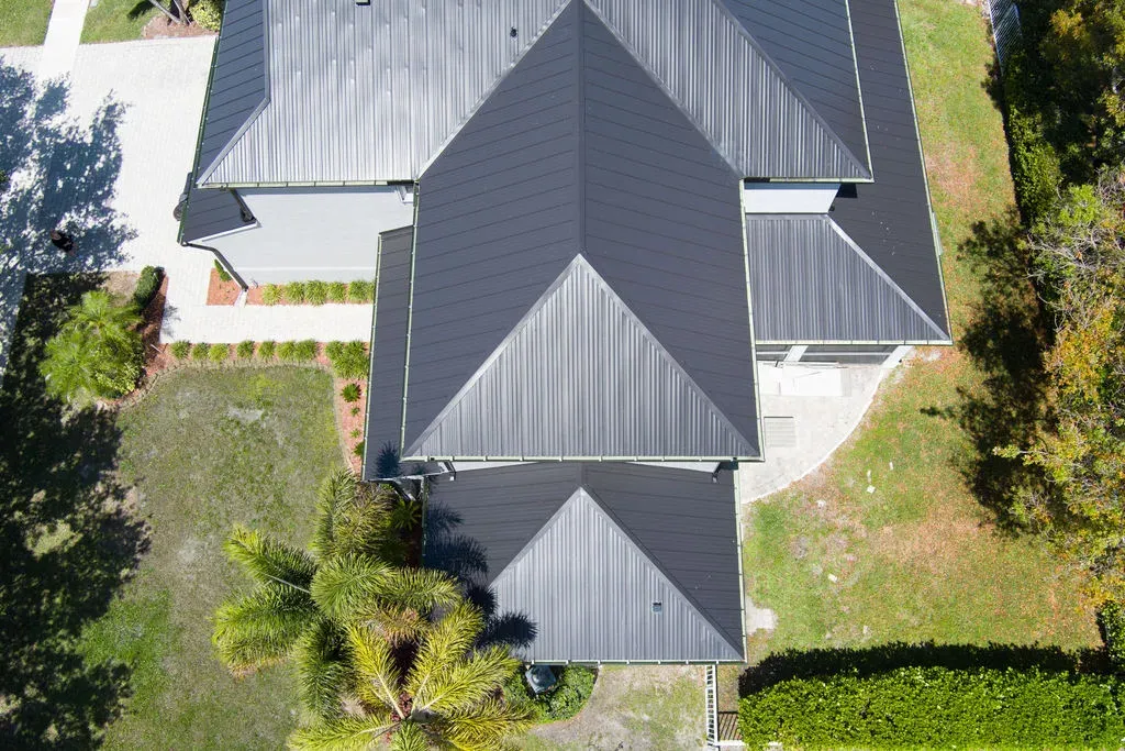 Aerial view of a modern home with a black metal roof and symmetrical design on the Treasure Coast