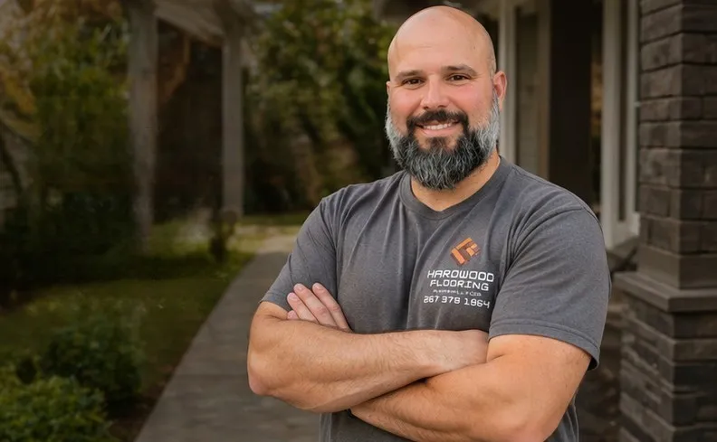 Christopher Gross, owner of Hardwood Flooring by Christopher, standing confidently in front of a home