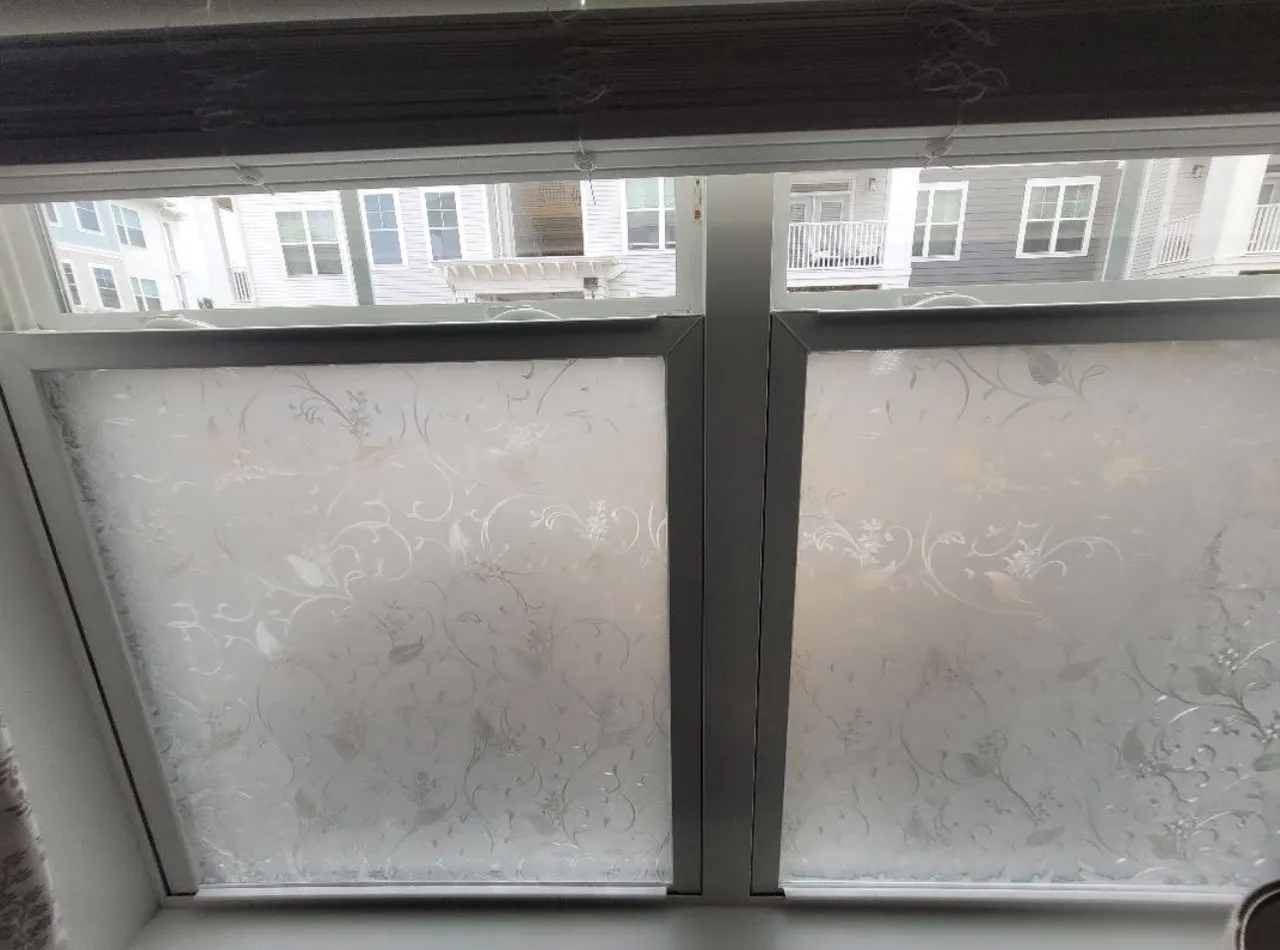 Window with frosted floral-pattern glass and wood trim ready for finish work